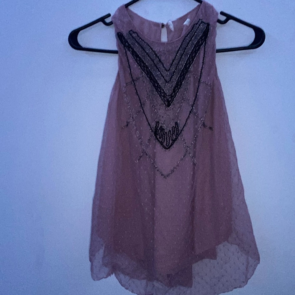 It’s a cute blouse with a dusty pick color. also has a bead design in the front.